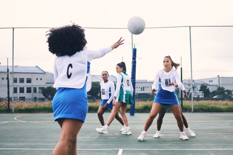 Équipe de netball s’entraînant sur un terrain extérieur avec un ballon en main.